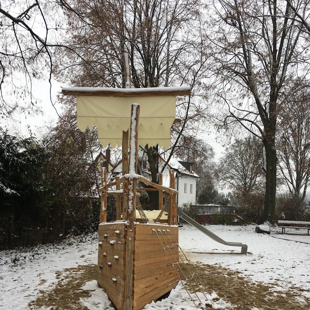 Wooden ship playground in snowy yard.